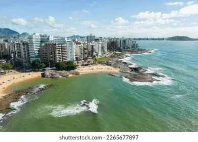 Orla de praia com prédios e mar esverdeado em Guarapari, Espírito Santo — 3LG Turismo